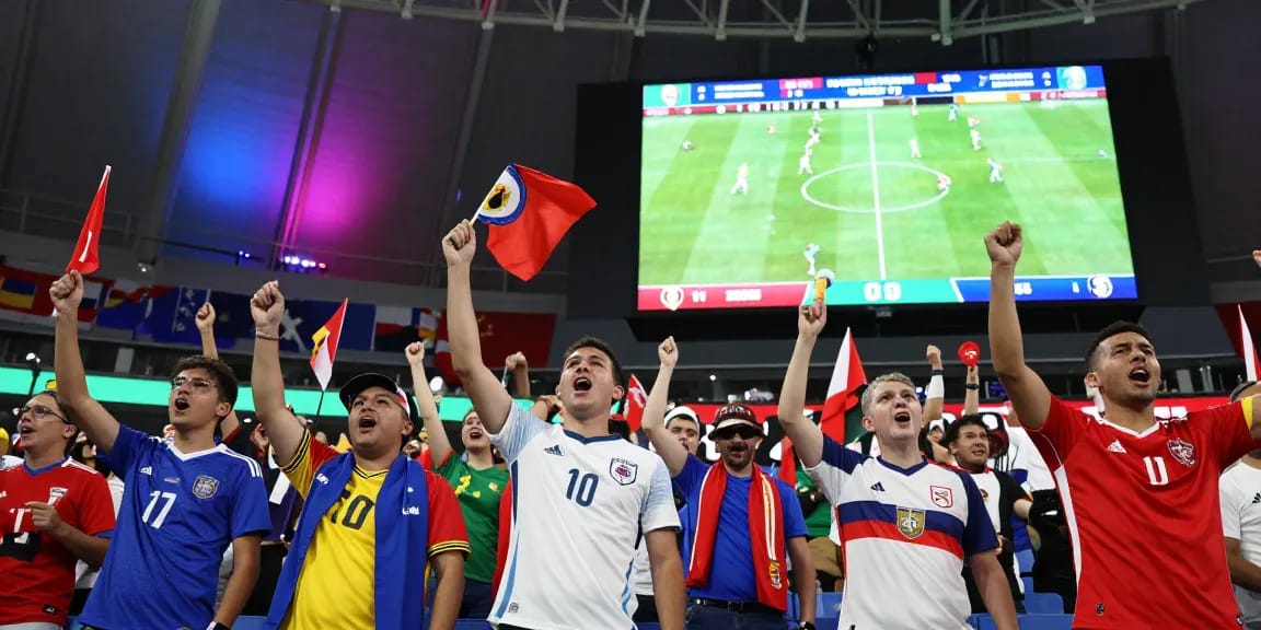 แฟนบอลที่กำลังเชียร์ฟุตบอลโลก 2026 เป็นภาพบรรยากาศที่น่าตื่นเต้น พร้อมราคาบอลโลกนัดชิงที่ประกาศบนจอใหญ่